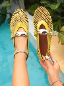 Gros plan sur les ballerines plates en maille jaune avec boucle en métal