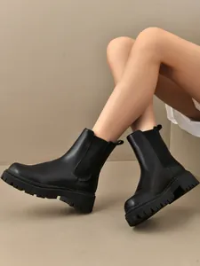 Détail de bottines Chelsea noires pour femmes avec semelle épaisse et empiècements