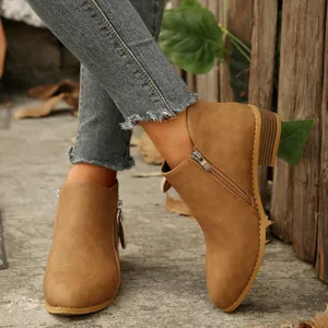 Detailed view of tan pointed toe ankle boots featuring double side zippers and block heels.