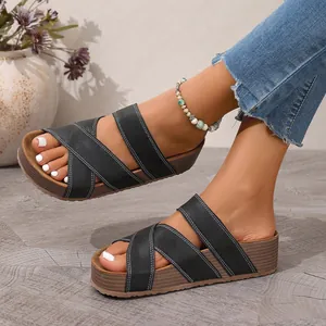 Detail shot of women's black cross-strap platform sandals with wood-grain thick sole
