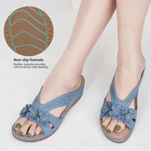 Detailansicht der rutschfesten Gummisohle dieser modischen blauen Keilsandalen mit Blumen