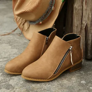 Exquisite close-up detail of tan pointed-toe ankle boots featuring stylish double side zippers