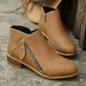 Detailed side view of camel suede ankle boots with double zippers and chunky heels