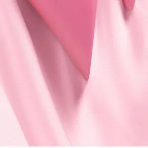Détail macro de la texture lisse du manche de rouleau antipeluche rose sur tissu rose