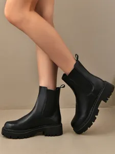 Bottines Chelsea noires à semelles compensées pour femmes portées par un mannequin