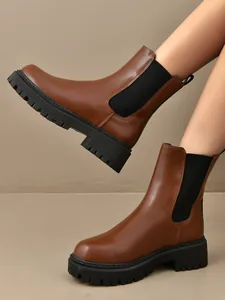 Gros plan de bottines Chelsea marron à plateforme avec des panneaux élastiques noirs