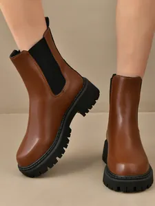 Vue détaillée de bottines Chelsea marron à plateforme dotées d'une semelle épaisse crantée.