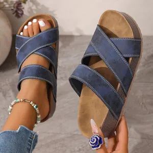 Detail view of stylish blue cross-strap platform sandals for women featuring thick soles