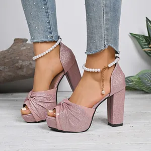 Gros plan sur les sandales rose pailleté à talons épais avec bride cheville perle