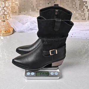 Close-up showing weight of black mid-calf Martin boots with side zipper detail
