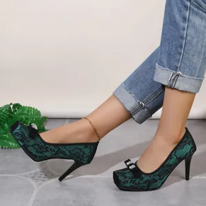 Detailansicht der grünen Spitzen-High-Heels mit quadratischer Spitze und Strassschleife