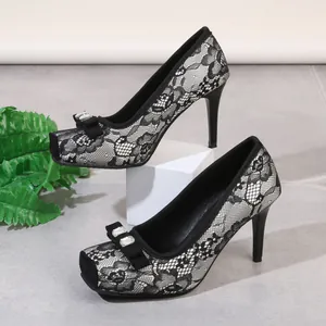 Detailansicht eleganter schwarzer Spitzen-Pumps mit quadratischer Spitze und Kristallschleife.