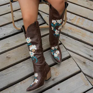 Detailed view of brown embroidered high-top western cowboy boots with floral patterns