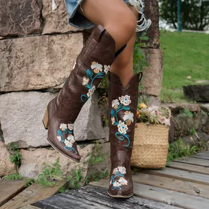 Detailed shot of women's tall brown western cowboy boots with floral embroidery