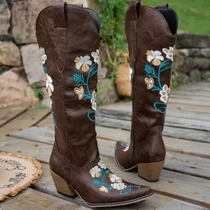 Detailed shot of brown tall western cowboy boots featuring intricate floral embroidery