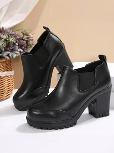 Side view of elegant black chunky heel platform ankle boots with elastic side panels