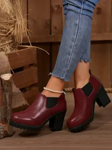 Detailed side view of elegant burgundy leather chunky heel platform ankle boots on model