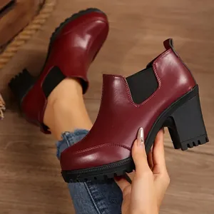 Close-up of wine red chunky heel ankle boots featuring textured platform soles