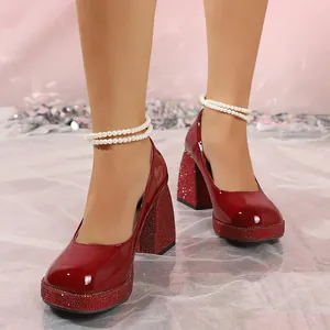 Detailed view of red patent leather Mary Jane shoes with beaded pearl ankle straps