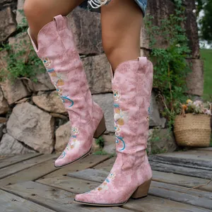 Detailed view of pink embroidered Western cowboy boots with V-cut and block heels