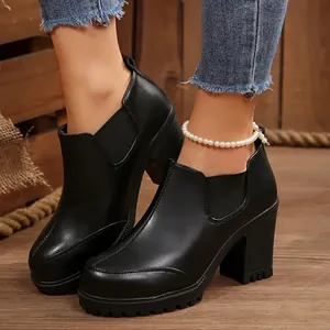 Detail view of black chunky high heel platform ankle boots with elastic side