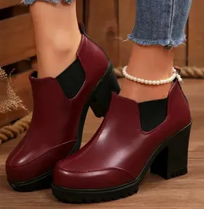 Side view detail of burgundy platform ankle boots with chunky heels and elastic sides.