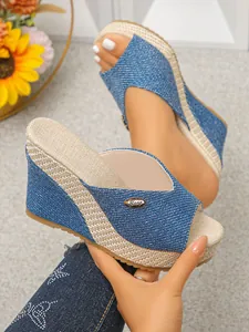 Detailed view of blue denim wedge sandals featuring a woven platform and open-toe design