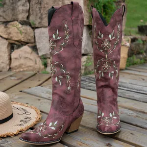 Detailed view of burgundy embroidered Western cowboy boots with V-mouth and chunky heel