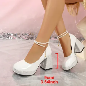 Detailed view of white patent leather 9cm thick heel Mary Janes with pearl strap