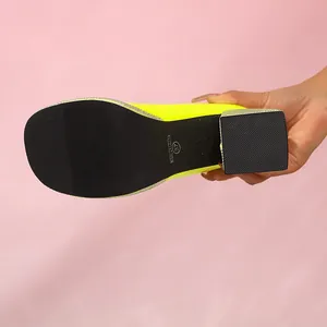 Close-up of black non-slip sole on neon yellow platform chunky heel shoe