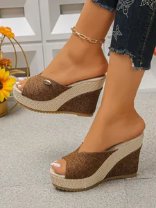 Close-up view of stylish brown fabric platform wedge slippers with woven heel on model