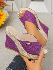 Close-up detail of stylish purple wedge sandals featuring a textured woven strap