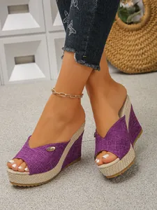 Close-up detail of purple woven wedge sandals with a thick platform and open toe design