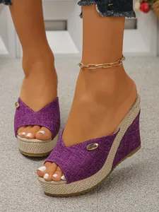 Detail of women's purple wedge platform slippers featuring woven texture and gold accent