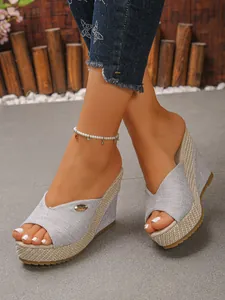 Close-up of women's silver glitter platform wedge sandals with peep toe design