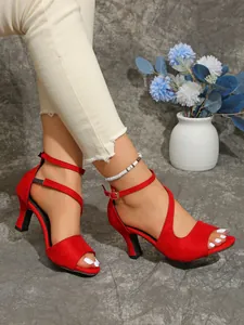 Detail view of stylish red ankle strap sandals with open toe design and chunky high heels