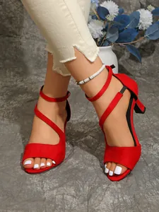 Close-up detail of stylish red suede high heel sandals with peep toe and ankle straps