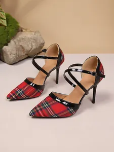 Close-up detail of stylish plaid pointed-toe high heels featuring black patent leather straps