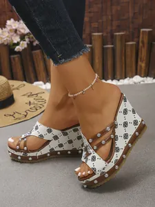 Detailansicht stilvoller Keilsandaletten aus bedrucktem Denim mit silbernen Metallnieten