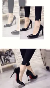 Detailed view of black patent leather pointed toe high heels with signature red soles