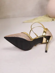 Detailed side view of golden glitter high heel sandals showing metallic stiletto and sole