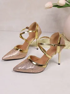 Detailed view of champagne gold glitter pointed-toe high heels with criss-cross straps