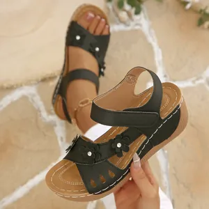 Retro black wedge Roman sandals featuring elegant floral details and hollow platform design