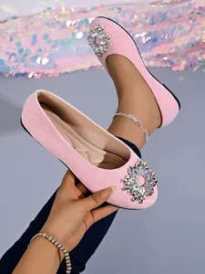 Detailansicht eleganter rosa Ballerinas mit luxuriös funkelnder Strassschnalle am runden Schuh