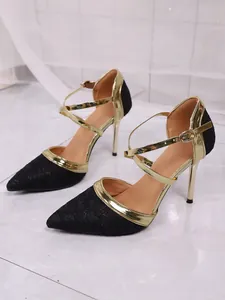 Close-up of black glitter and gold metallic pointed-toe stiletto high heel sandals
