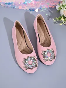 Detailansicht pinkfarbener flacher Schuhe mit funkelnden Strassblumen-Schnallen.