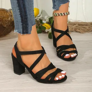 Elegant black crisscross strap sandals featuring block heels and a stylish open-toe design
