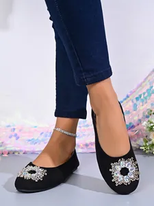 Detailansicht der schwarzen Ballerinas mit runder Strassschnalle und weicher Sohle.