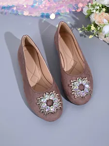Detailaufnahme der taupefarbenen Wildleder-Ballerinas mit brillantem Strass-Ornament auf der Zehe.