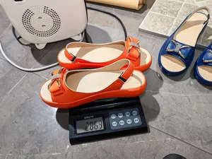 Detailed view of fashionable rhinestone bow sandals being weighed on a digital scale
